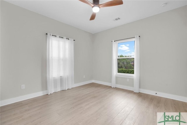 empty room with light wood finished floors, visible vents, baseboards, and ceiling fan