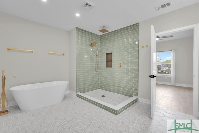 bathroom featuring tiled shower, a soaking tub, and visible vents