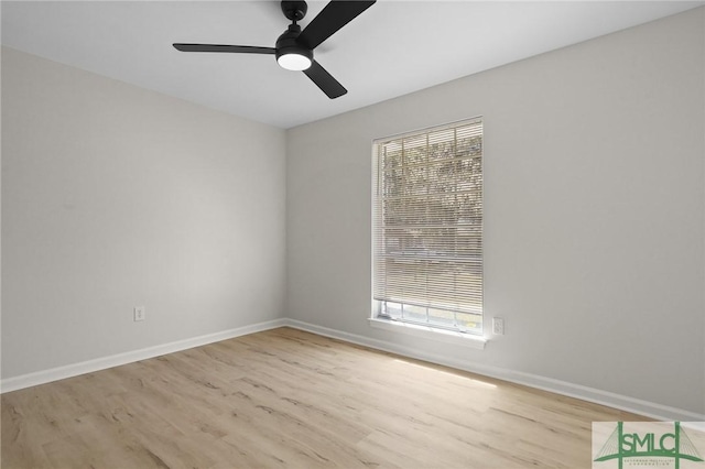 spare room with baseboards, ceiling fan, and wood finished floors