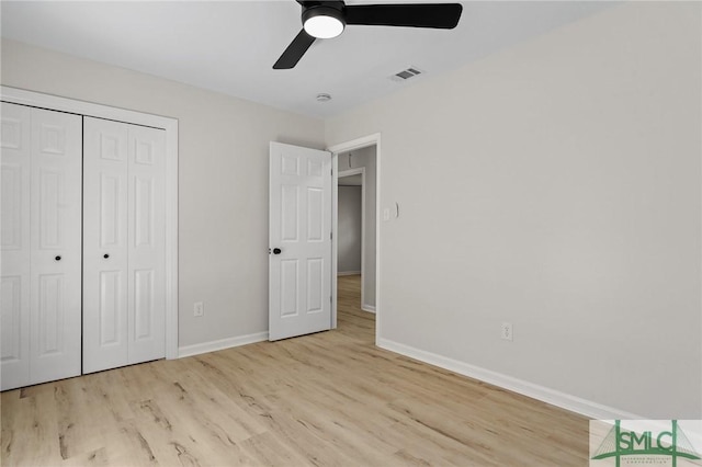 unfurnished bedroom with baseboards, a closet, wood finished floors, and ceiling fan