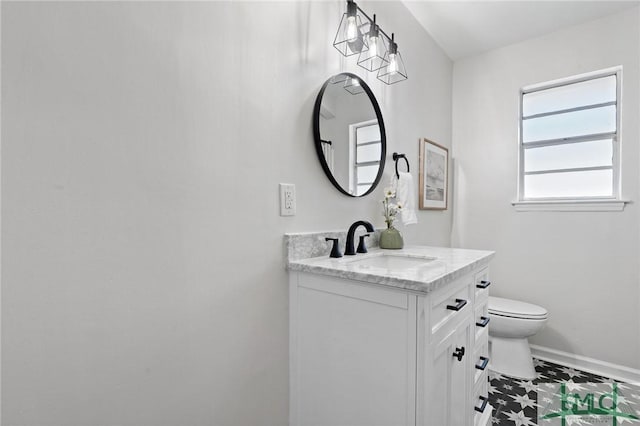 half bathroom with baseboards, toilet, and vanity