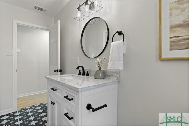 bathroom featuring vanity, baseboards, and visible vents