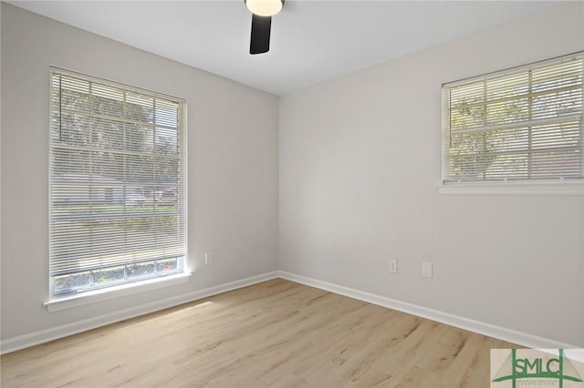 empty room featuring wood finished floors, baseboards, and ceiling fan