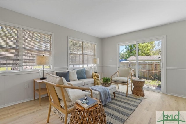 living area with baseboards and wood finished floors