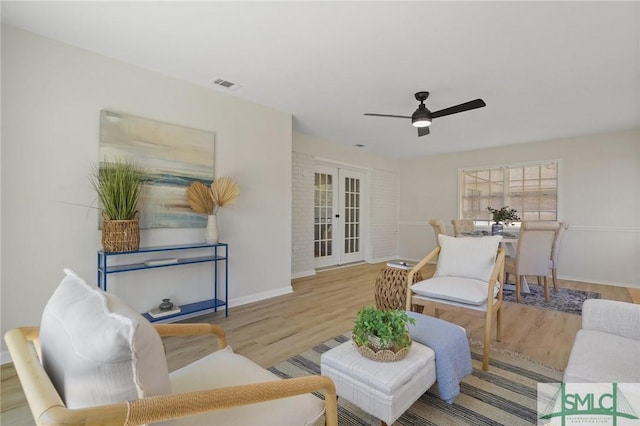 living room with french doors, wood finished floors, baseboards, visible vents, and ceiling fan