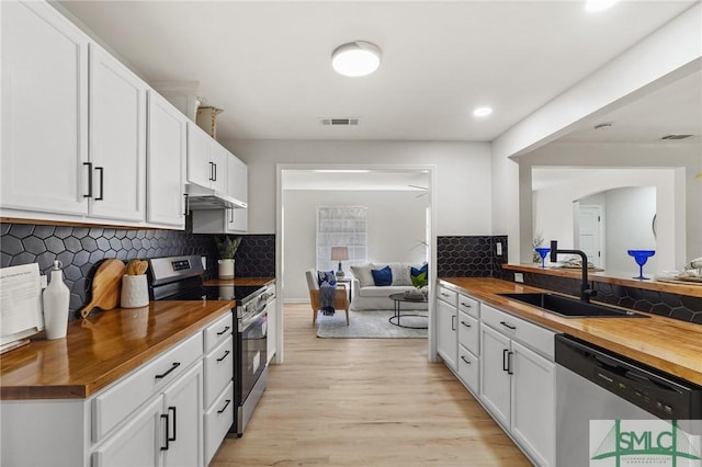 kitchen with visible vents, wood counters, stainless steel appliances, a sink, and light wood-type flooring