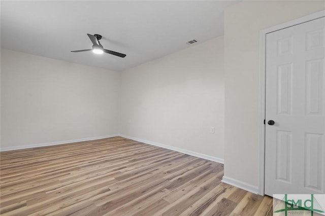 empty room featuring baseboards, visible vents, light wood-style floors, and ceiling fan