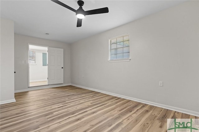 empty room with baseboards, ceiling fan, and light wood-type flooring