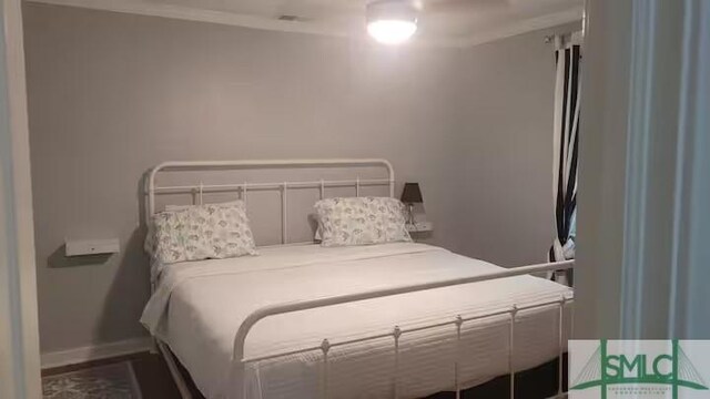 bedroom with baseboards and crown molding