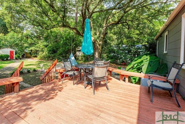 wooden deck with an outdoor structure and outdoor dining space