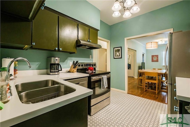 kitchen featuring light countertops, under cabinet range hood, baseboards, a sink, and appliances with stainless steel finishes