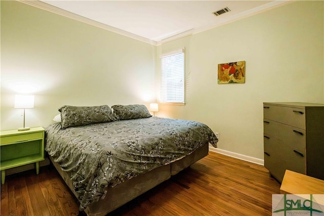 bedroom with visible vents, ornamental molding, baseboards, and wood finished floors