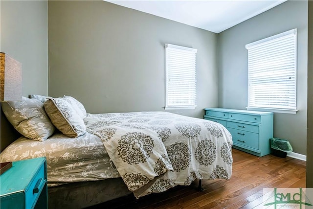 bedroom featuring baseboards and wood finished floors