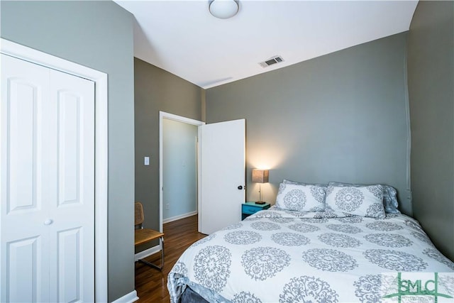 bedroom with visible vents, a closet, and dark wood-type flooring