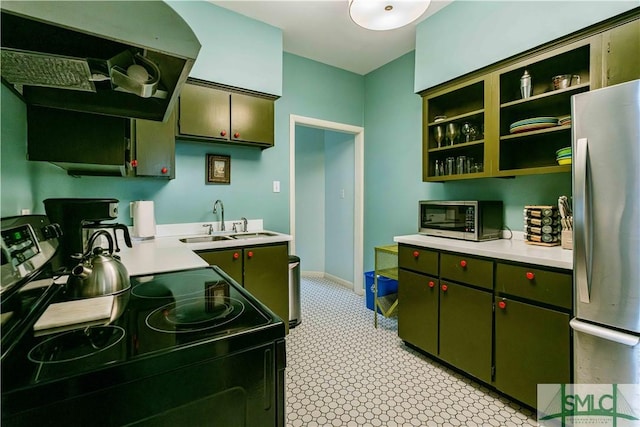 kitchen with green cabinets, light countertops, appliances with stainless steel finishes, a sink, and open shelves
