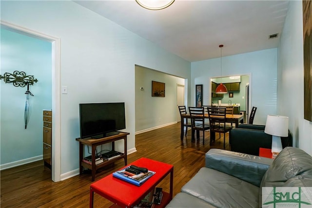 living room featuring wood finished floors, baseboards, and visible vents