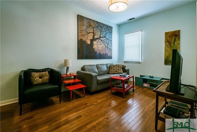 living area with wood-type flooring, baseboards, and visible vents