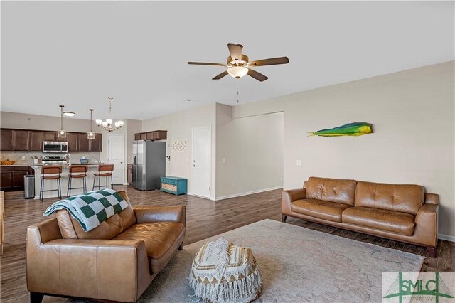 218 Herty Ln, Hinesville, GA 31313 - living area featuring a ceiling fan, a chandelier, dark wood-style floors, and baseboards