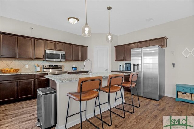 218 Herty Ln, Hinesville, GA 31313 - kitchen featuring appliances with stainless steel finishes, a sink, dark brown cabinetry, backsplash, and light wood-style flooring