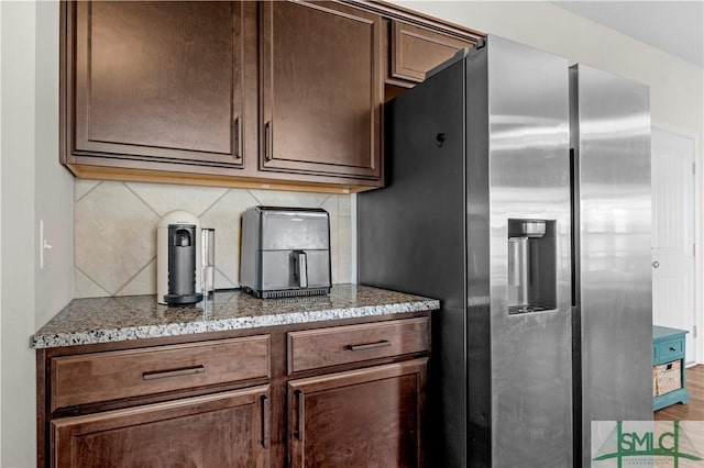 218 Herty Ln, Hinesville, GA 31313 - kitchen featuring stainless steel refrigerator with ice dispenser, tasteful backsplash, stone counters, and dark brown cabinetry
