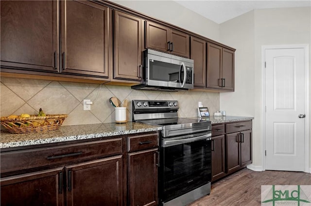218 Herty Ln, Hinesville, GA 31313 - kitchen with appliances with stainless steel finishes, dark brown cabinets, light stone countertops, and decorative backsplash