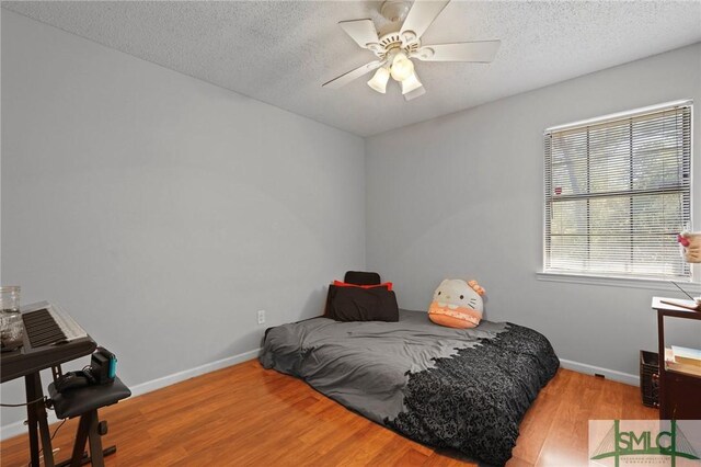 726 Timber Ridge Trl, Hinesville, GA 31313 - bedroom featuring baseboards, a textured ceiling, and wood finished floors