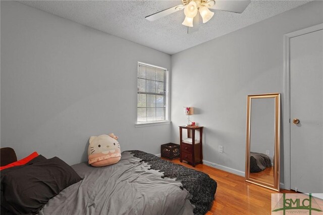 726 Timber Ridge Trl, Hinesville, GA 31313 - bedroom with baseboards, light wood-type flooring, a ceiling fan, and a textured ceiling