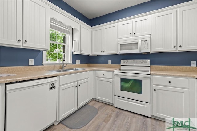 90 Cottage Ct, Richmond Hill, GA 31324 - kitchen with light countertops, a sink, light wood finished floors, white appliances, and white cabinets