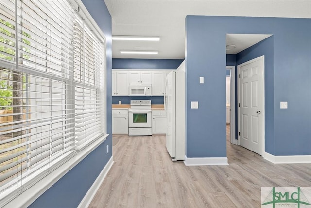 90 Cottage Ct, Richmond Hill, GA 31324 - kitchen with white cabinetry, baseboards, light wood finished floors, and white appliances
