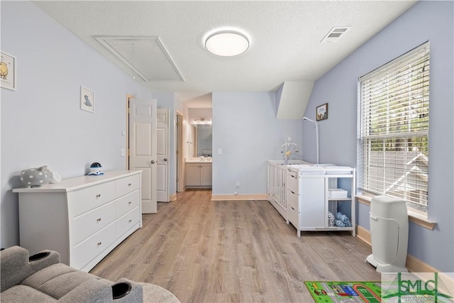 90 Cottage Ct, Richmond Hill, GA 31324 - interior space featuring attic access, light wood-type flooring, baseboards, a textured ceiling, and visible vents