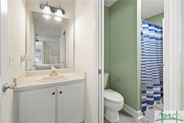 90 Cottage Ct, Richmond Hill, GA 31324 - bathroom featuring baseboards, toilet, wood finished floors, curtained shower, and vanity