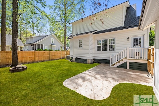 90 Cottage Ct, Richmond Hill, GA 31324 - rear view of house featuring roof with shingles, cooling unit, fence, a patio, and a yard