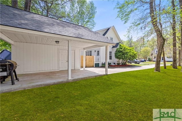 90 Cottage Ct, Richmond Hill, GA 31324 - exterior space featuring an attached carport, roof with shingles, a patio, and a yard