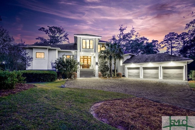 28 Delegal Rd, Savannah, GA 31411 - view of front of property with a front lawn, decorative driveway, stucco siding, and a garage