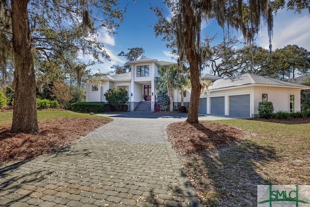 28 Delegal Rd, Savannah, GA 31411 - view of front of property with stucco siding, an attached garage, and decorative driveway