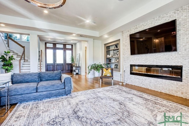 28 Delegal Rd, Savannah, GA 31411 - living room with stairway, built in shelves, wood finished floors, a glass covered fireplace, and recessed lighting