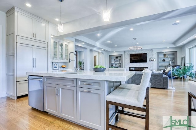 28 Delegal Rd, Savannah, GA 31411 - kitchen featuring a large fireplace, light wood-style flooring, a sink, open floor plan, and gray cabinets