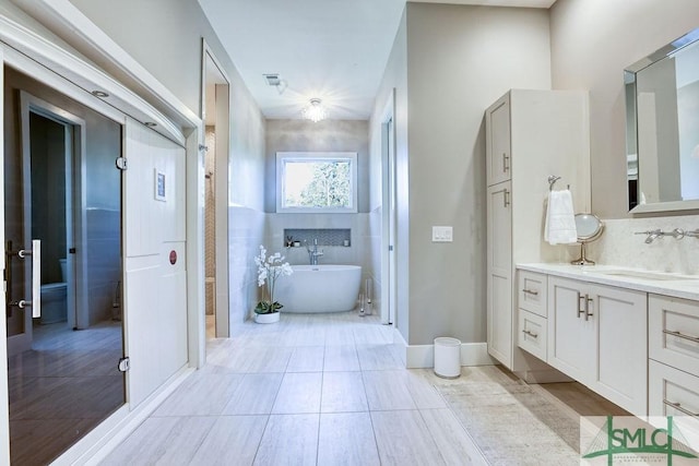 28 Delegal Rd, Savannah, GA 31411 - full bathroom featuring tile patterned flooring, vanity, a freestanding tub, backsplash, and visible vents