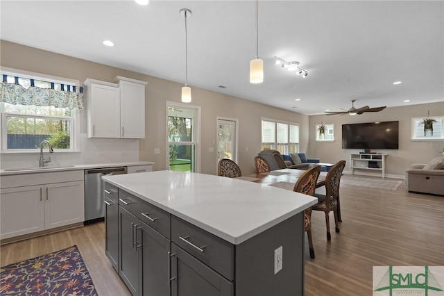 126 Canter Ct, Savannah, GA 31406 - kitchen featuring stainless steel dishwasher, a sink, open floor plan, light wood-style flooring, and light countertops