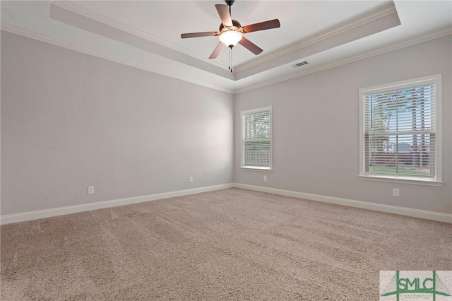 unfurnished room featuring visible vents, baseboards, ceiling fan, light carpet, and a tray ceiling