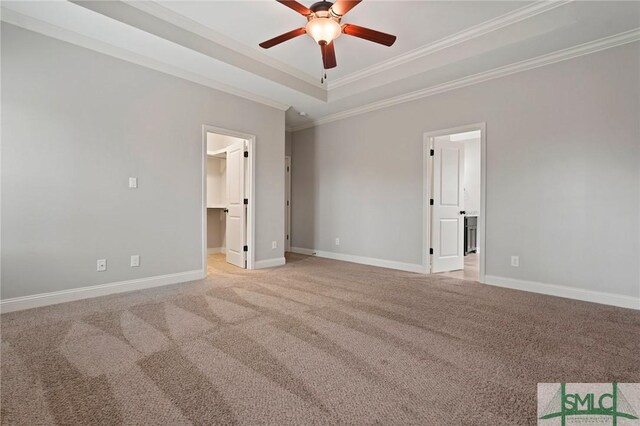 unfurnished room featuring a tray ceiling, light carpet, ceiling fan, and ornamental molding