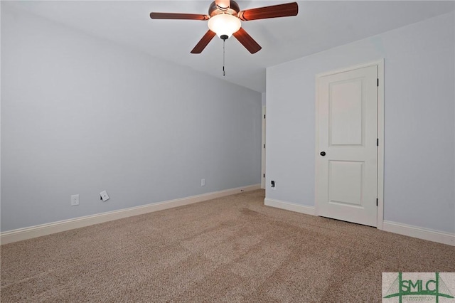 carpeted spare room featuring baseboards and ceiling fan