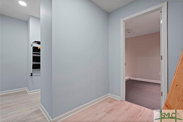 hallway with baseboards and wood finished floors