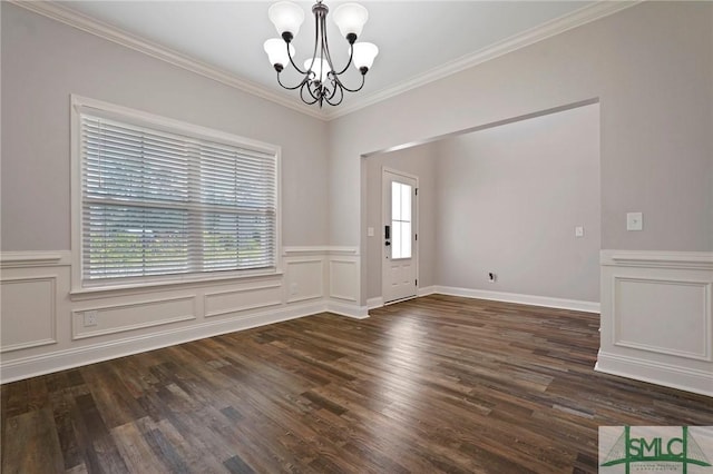 interior space with a decorative wall, ornamental molding, wood finished floors, an inviting chandelier, and wainscoting