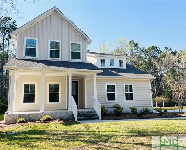 125 Long Creek Ln, Richmond Hill, GA 31324 - view of front of house featuring a porch, a front lawn, and board and batten siding