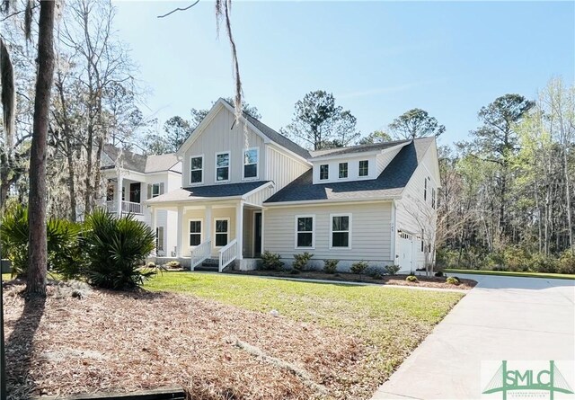 125 Long Creek Ln, Richmond Hill, GA 31324 - modern inspired farmhouse featuring an attached garage, concrete driveway, a front lawn, and covered porch