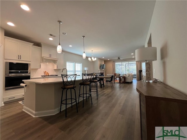 125 Long Creek Ln, Richmond Hill, GA 31324 - kitchen featuring open floor plan, a center island with sink, dark wood finished floors, plenty of natural light, and recessed lighting