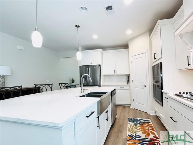 125 Long Creek Ln, Richmond Hill, GA 31324 - kitchen featuring appliances with stainless steel finishes, a sink, light wood-style floors, white cabinets, and recessed lighting