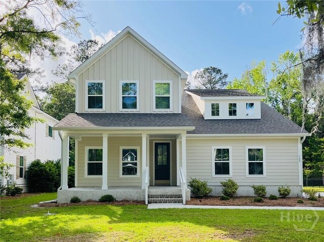 125 Long Creek Ln, Richmond Hill, GA 31324 - view of front facade with a porch, a front lawn, a shingled roof, and board and batten siding