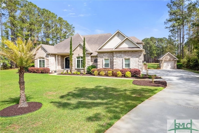 view of front of home featuring concrete driveway, a front lawn, an outbuilding, and a detached garage